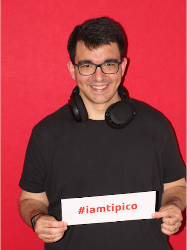 Male software developer smiling and holding a sign that reads 'I am Tipico,' his new company.